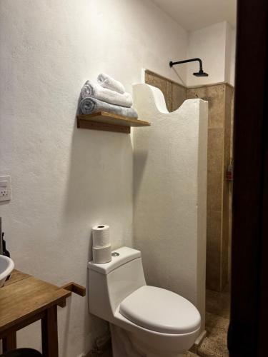 a bathroom with a toilet and a sink and towels at Casa Luminara in Guanajuato