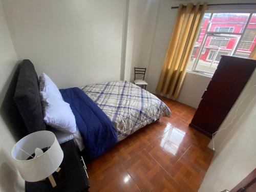 a small bedroom with a bed and a window at El refugio de Lolita, tu hogar en Loja in Loja