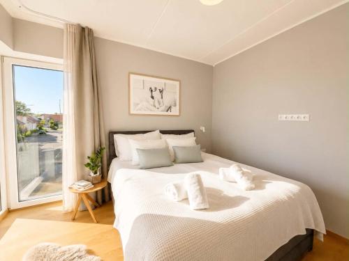 a bedroom with a large white bed with towels on it at Sadama Apartment in Haapsalu