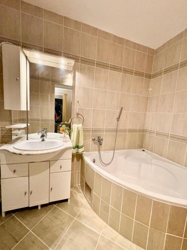 a bathroom with a tub and a sink at Apartments Mirian in Petrovac na Moru