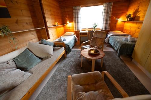 a living room with a couch and chairs in a cabin at Kyyronkaita in Mikkeli