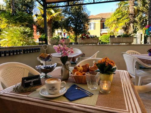 a table with a tray of food and a cup of coffee at Hotel Villa Pina in Senigallia