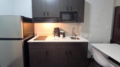 a small kitchen with a sink and a refrigerator at Studio 6-Brownsville, TX in Brownsville
