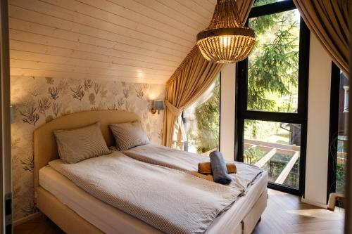 a bedroom with a bed with a teddy bear on it at ORO Baltic in Pobierowo