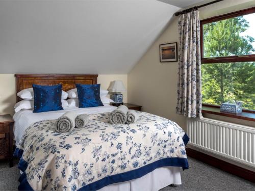 a bedroom with a bed with blue and white sheets and a window at 3 Bed in Swansea oc-bn172 in Ystalyfera