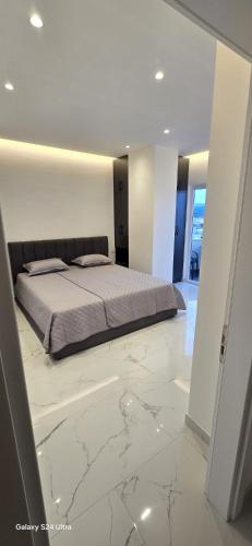a bedroom with a bed and a marble floor at DLE Murtic in Shëngjin