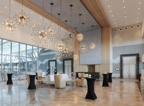 a lobby with chandeliers and tables and chairs at The Ankara Hotel in Ankara