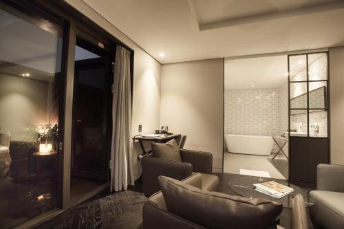 a living room with a couch and chairs and a table at Hotel Gaden in Suwon