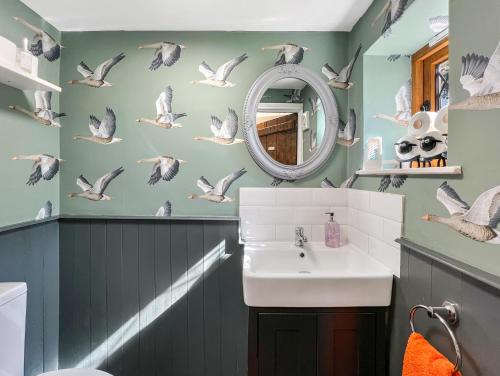 a bathroom with a sink and birds on the wall at Sharpe Cottage Wiveliscombe in Wiveliscombe