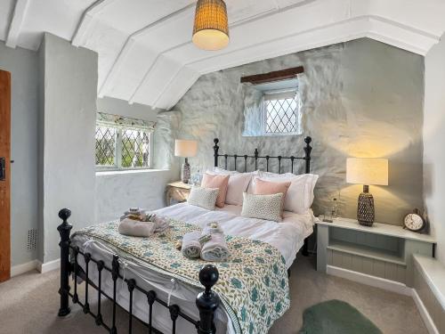 a bedroom with a large bed with pink pillows at Sharpe Cottage Wiveliscombe in Wiveliscombe