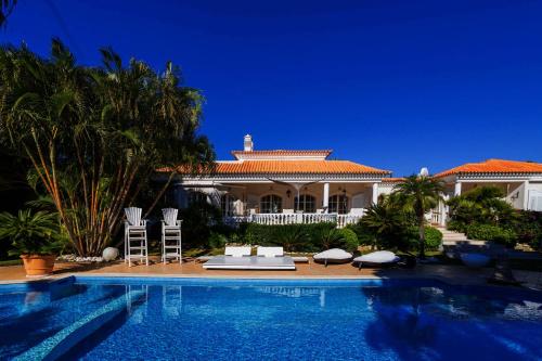 a house with a swimming pool in front of a house at Tranquil Algarve Escape in Faro