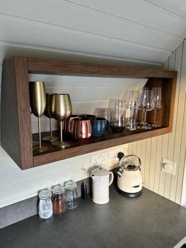 a kitchen counter with glasses and utensils on a shelf at The Hare's Lair in Monaghan