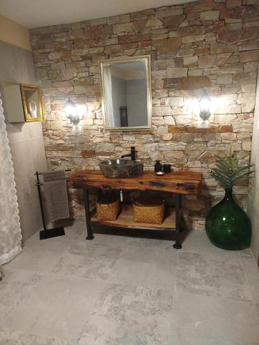 a bathroom with a sink and a stone wall at Studio Lanisa in Kanal
