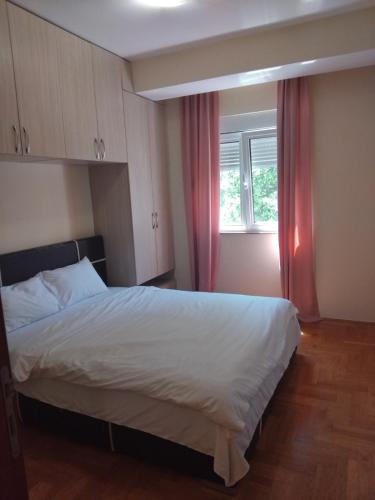 a bedroom with a bed and a window with red curtains at Apartman Budva in Budva