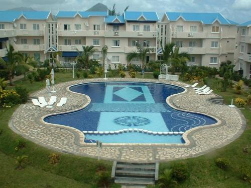 - une vue sur la piscine en face d'un bâtiment dans l'établissement Le Datier Luxury Complex, à Flic-en-Flac