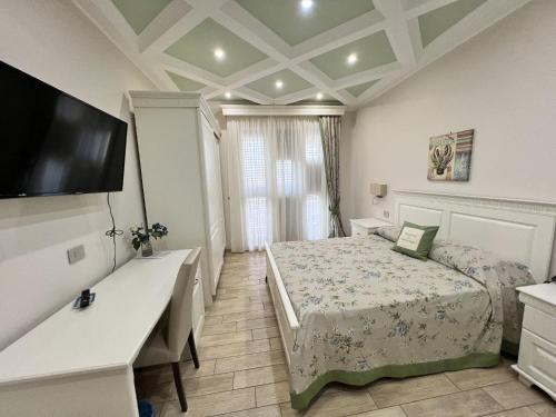 a bedroom with a bed and a desk and a television at Stella del Mare in Licata