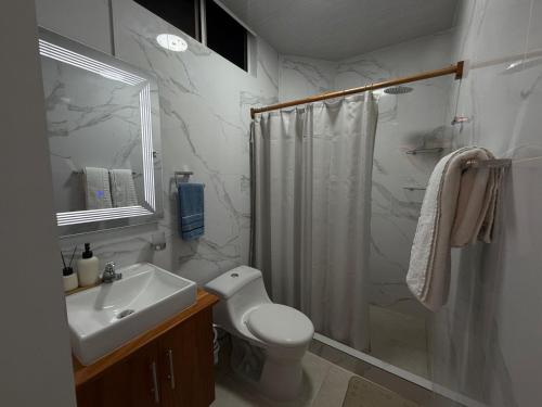 a bathroom with a shower and a toilet and a sink at Suite Rosedelco in Puerto Villamil