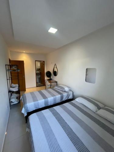 two beds in a hotel room with two beds at Pousada Aconchego in São Mateus