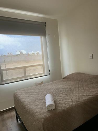a bedroom with a bed and a window with a view at Comfortable, equipped house for long stays in Juriquilla