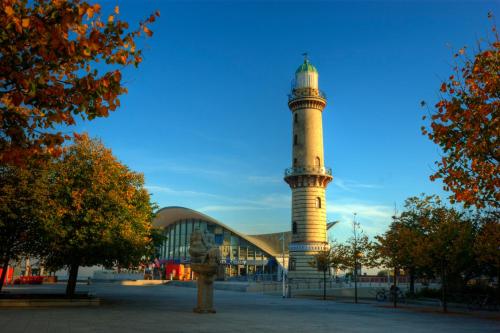 a building with a lighthouse in front of a building at KurparkHotel Warnemünde in Warnemünde