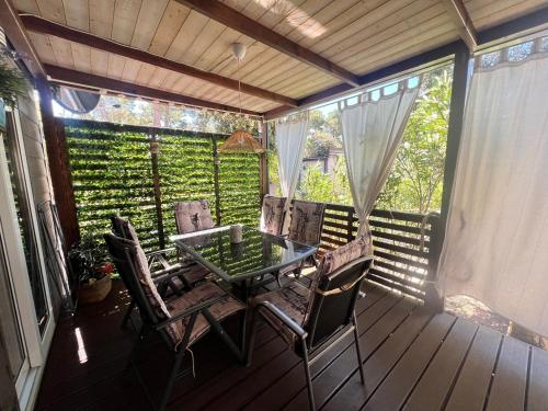 a patio with a table and chairs on a deck at LunaSky Biograd Mobile Home in Biograd na Moru