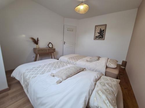 two beds in a room with white walls at Au pré de Mimi in Lalande-en-Son