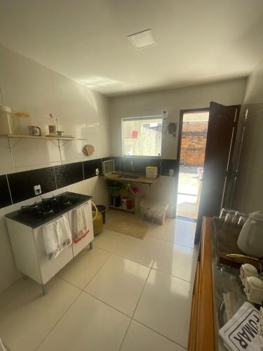 a kitchen with a stove and a white floor at Pousada Aconchego in São Mateus