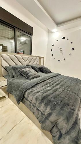 a bedroom with a large bed and a clock on the wall at مدينة الشرق الزرقاء in Az Zarqa