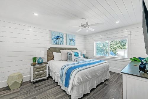a white bedroom with a bed and a window at Coconuts Beachfront #112 in Holmes Beach