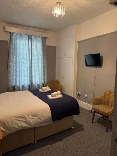 a bedroom with a bed with two towels on it at Sterling Lodge Hotel in Eastbourne