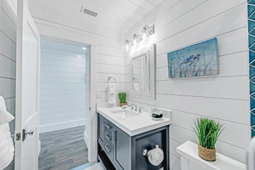 a white bathroom with a sink and a mirror at Coconuts Beachfront #112 in Holmes Beach
