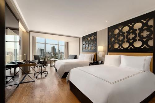 a hotel room with two beds and a desk at Hilton Lima Miraflores in Lima