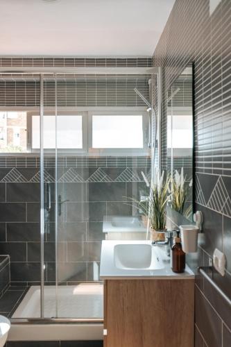 a bathroom with a sink and a shower and a tub at Home Corinto Beach terraza y piscina - Benalmadena Malaga in Benalmádena