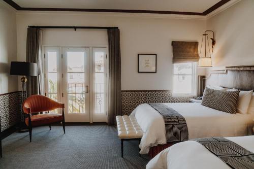 a hotel room with two beds and a chair at Hotel Californian in Santa Barbara