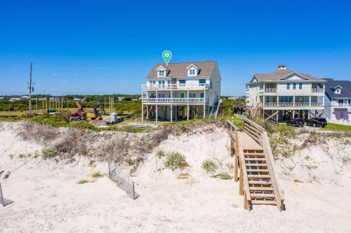 a house on top of a beach with a wooden ramp at Oceanfront with Private Beach Access Sunset Views in Sneads Ferry