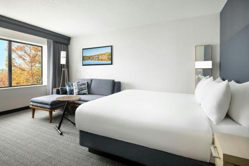 a hotel room with a bed and a chair at Courtyard by Marriott Concord in Concord