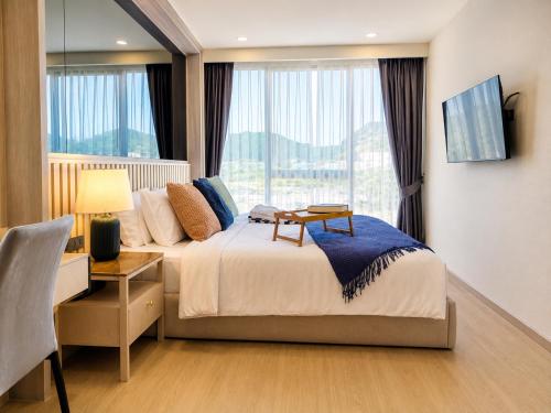 a hotel room with a bed and a window at Cozy 1 BR Bangtao Beach in Laguna Phuket