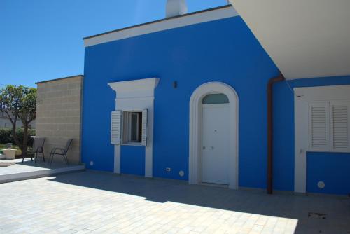 a blue building with a white door and a patio at Kasamare- Monopoli in Monopoli