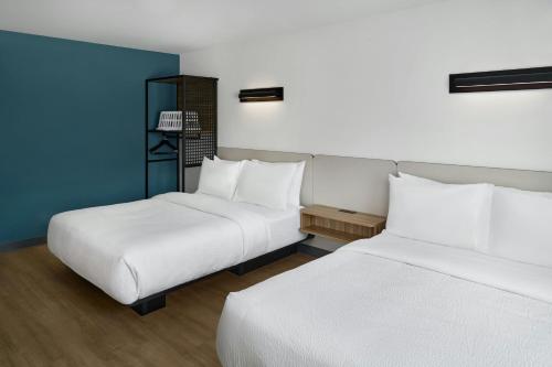 two beds in a hotel room with white sheets at StudioRes by Marriott Columbia Harbison in Columbia