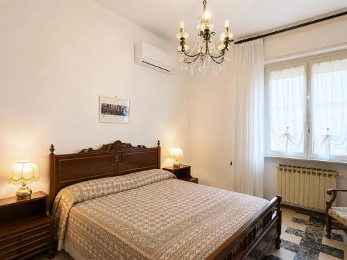 a bedroom with a bed and a chandelier at Sea View Apartment - Private Parking AC in Savona