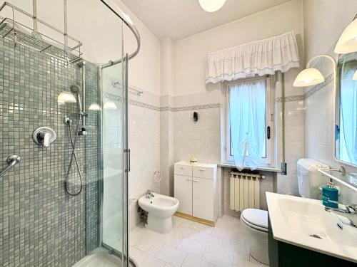 a bathroom with a shower and a toilet and a sink at Sea View Apartment - Private Parking AC in Savona