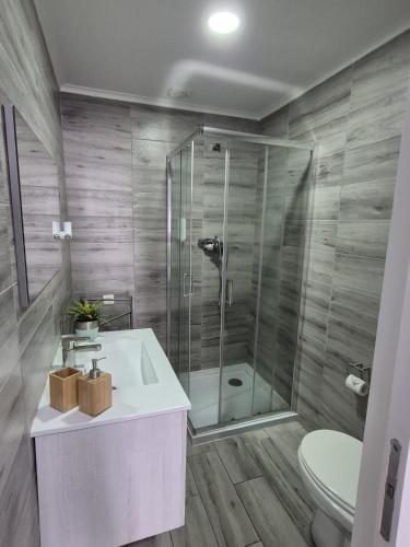 a bathroom with a shower and a sink and a toilet at V4 in Horta
