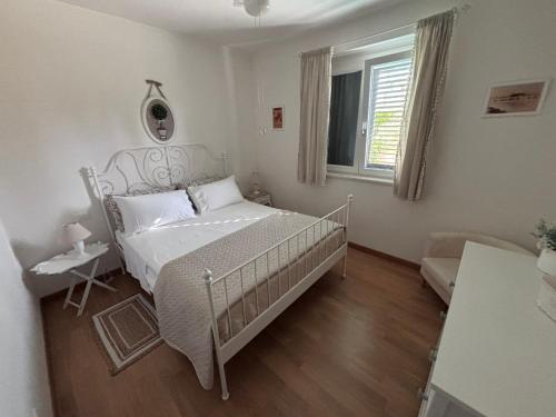 a bedroom with a white bed and a window at Appartamento Verde Golf in Miglianico