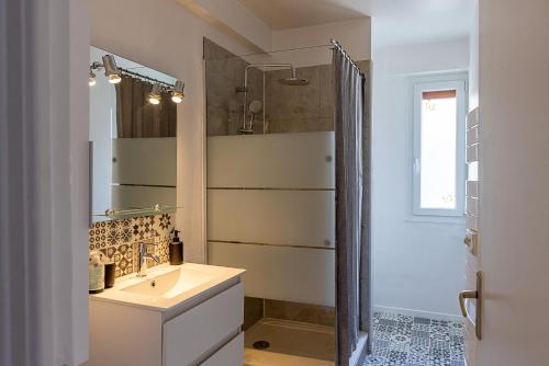 a bathroom with a sink and a shower at Le Cadélac - appartement centre ville cosy in Loudéac