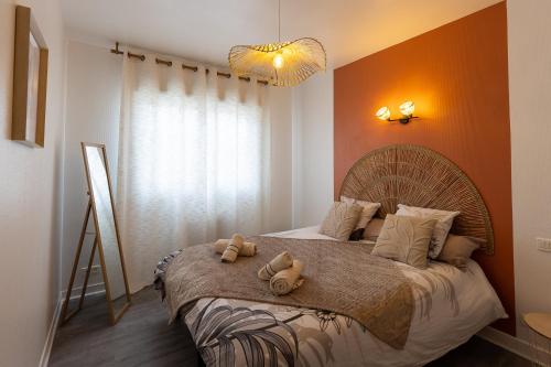 a bedroom with a bed with two teddy bears on it at Le Cadélac - appartement centre ville cosy in Loudéac
