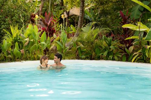 a man and a woman in a swimming pool at Magic Green Dentro del Parque Tayrona in El Zaino