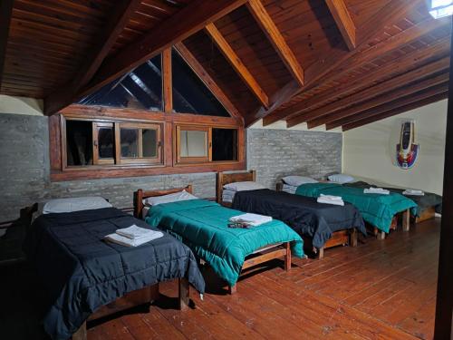 a group of four beds in a room with windows at Cabañas Lodge Angirú in Goya
