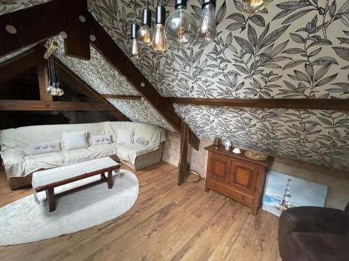 a living room with a staircase with a couch and a table at Le Breizh des Bois in Le Faouët