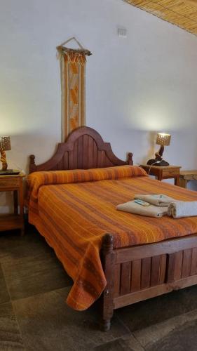a bedroom with a large bed with an orange blanket at Cardones de Molinos in Molinos