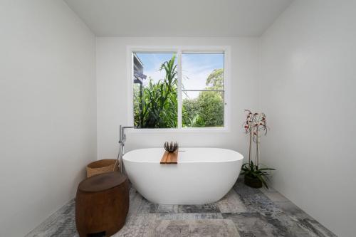 a white bathroom with a tub and a window at Mysa Homestead in Tonimbuc